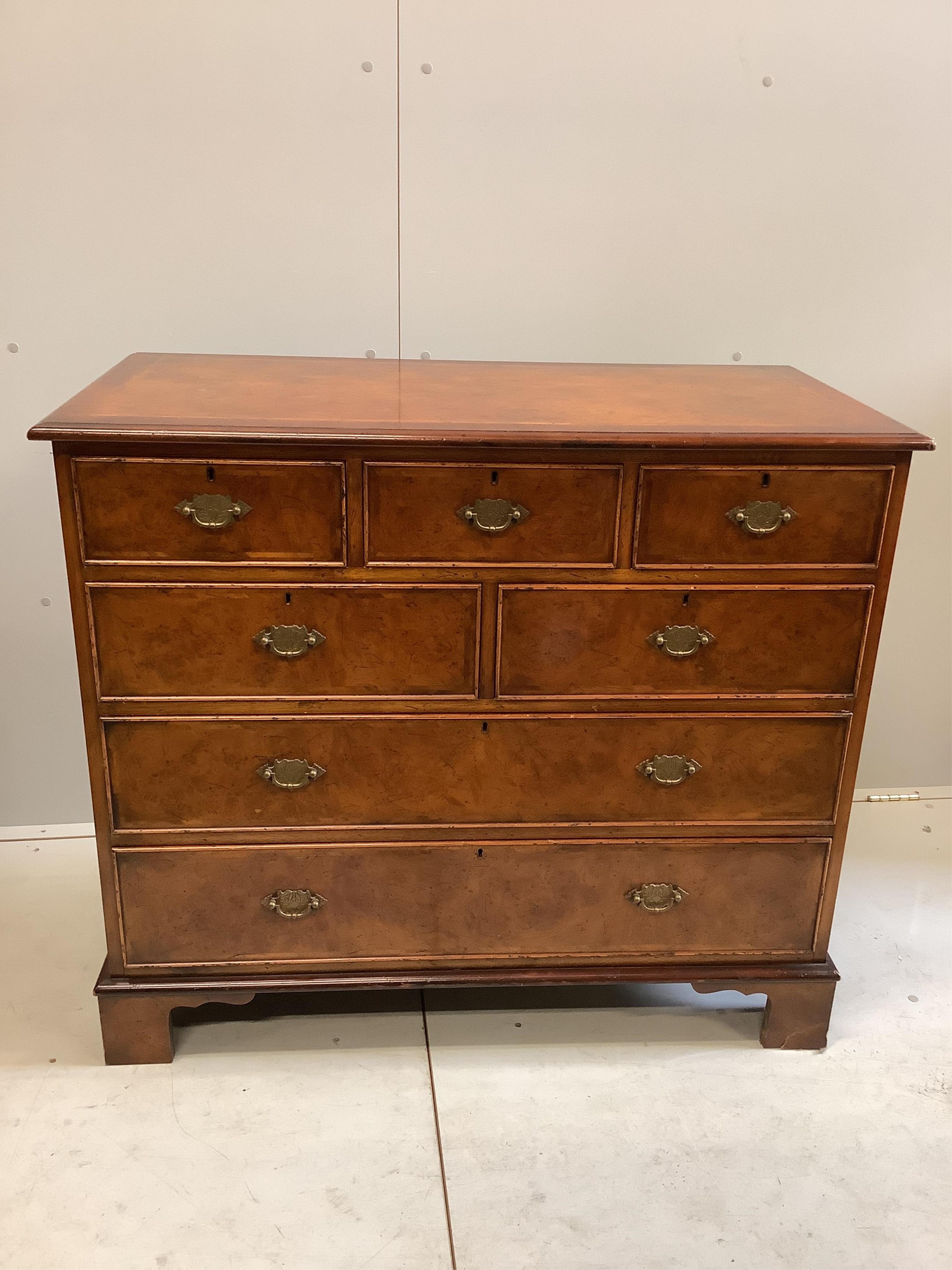 A pair of reproduction George I style feather banded walnut chests of drawers, width 104cm, depth 50cm, height 91cm